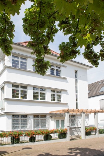 Eingang mit Pergola und Blumenkästen